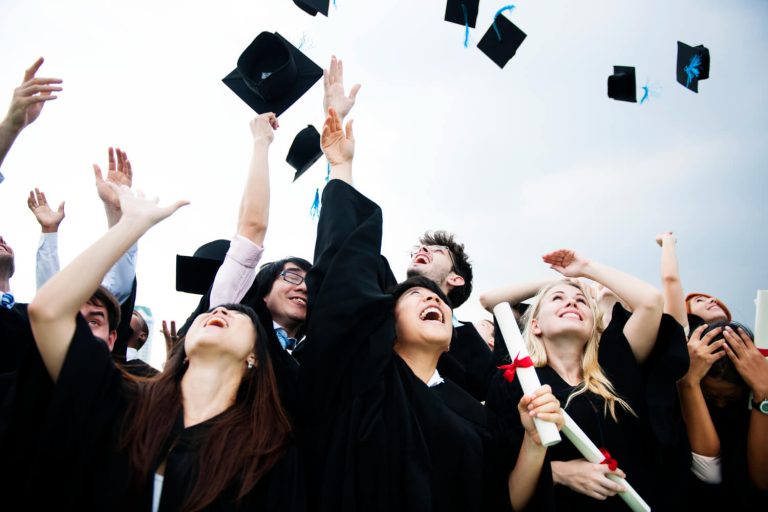 group-diverse-grads-throwing-caps-up-sky-1.jpg